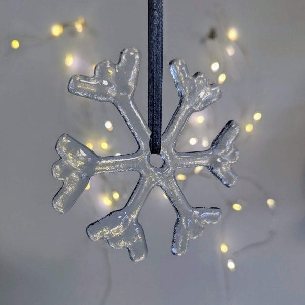 Glass Snowflake with fairy lights behind.