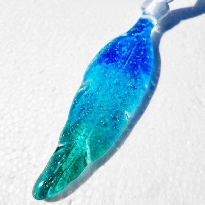 Blue ashes keepsake glass feather on a white background