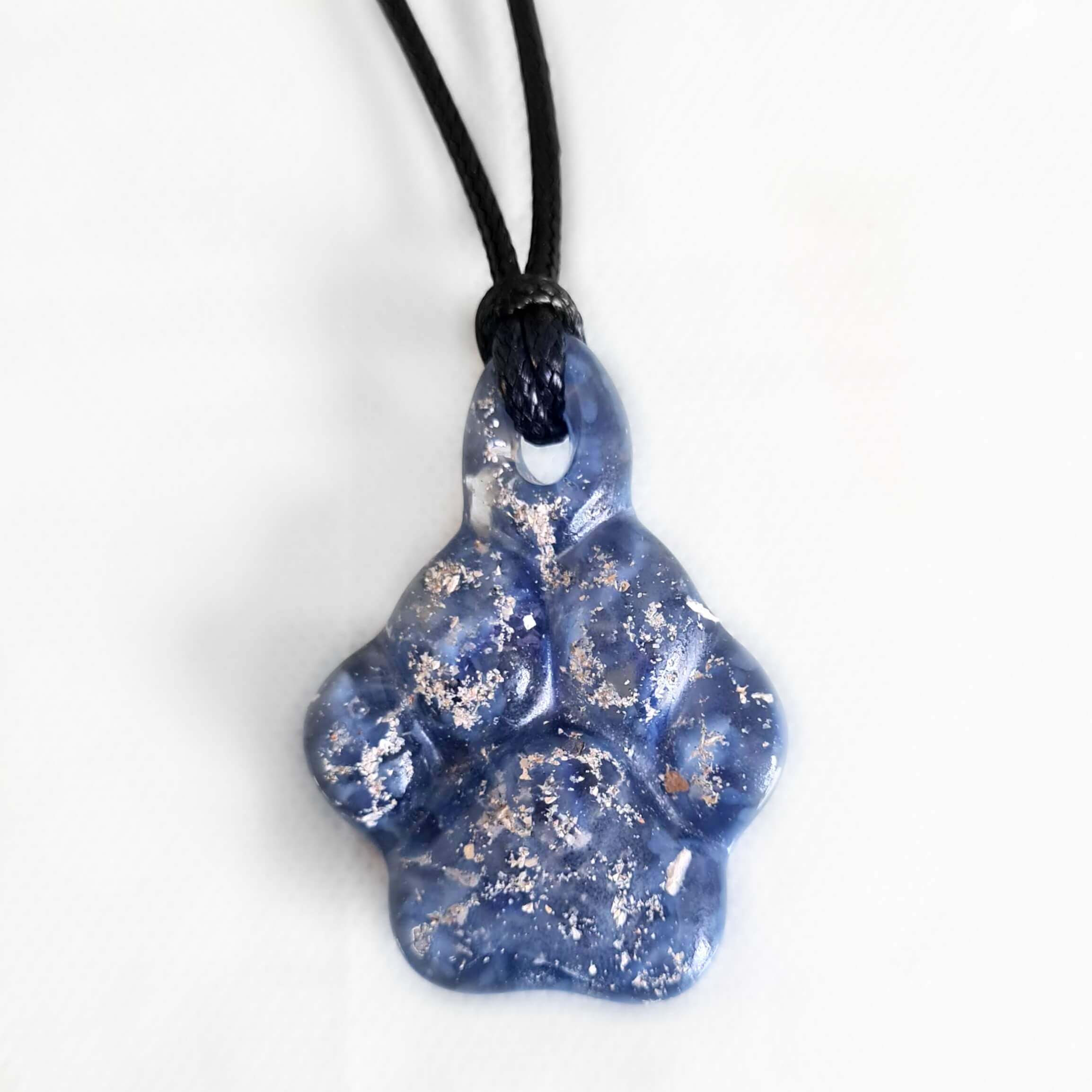 A grey/blue ashes in glass paw print necklace
