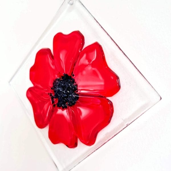A Red & Black glass poppy on a white background