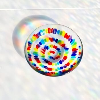 A Spiral Rainbow Bowl showing Rainbow coloured shadows on a white background