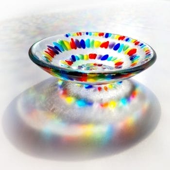 A Spiral Rainbow Bowl showing Rainbow coloured shadows on a white background
