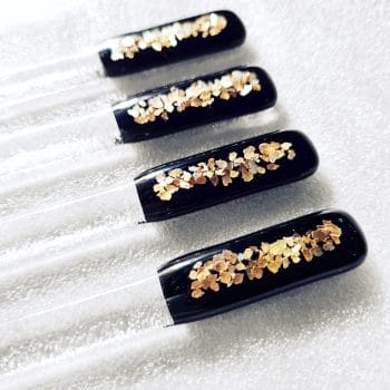 Black and gold sparkly swizzlesticks on a white background