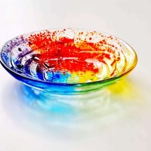 a rainbow coloured handmade glass bowl with rainbow colours and texture