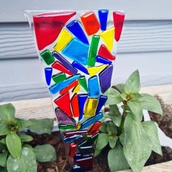 A rainbow glass plant stake in a pot