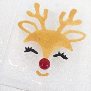 A golden reindeer with black eyelashes and a red nose